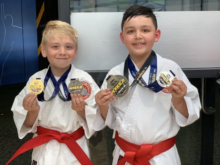 smiling young boys both showing their silver and gold medals