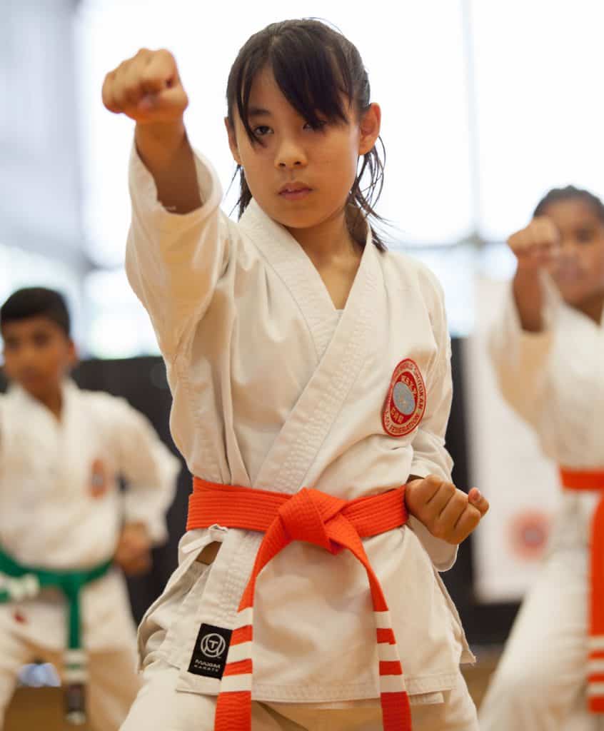 junior girl showing a focused head punch